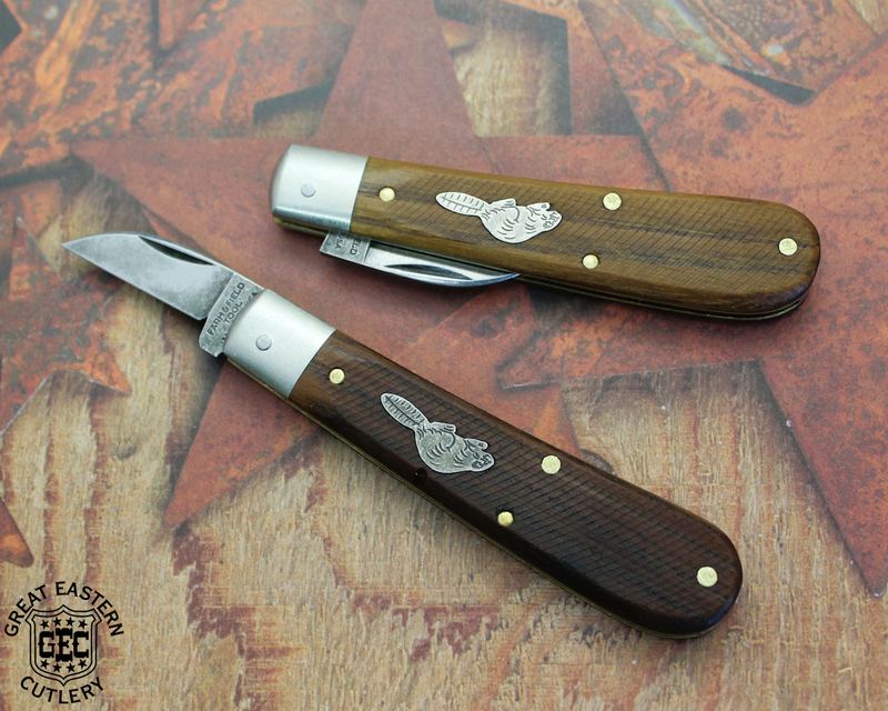 Two Farm and Field Tool jack knives with checkered wood handles and steel bolsters on a rustic painted-star background