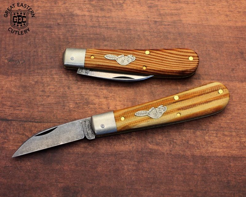 Two Farm and Field Tool knives with sawcut wood handles, one open showing a wharncliffe blade, on a wooden tabletop